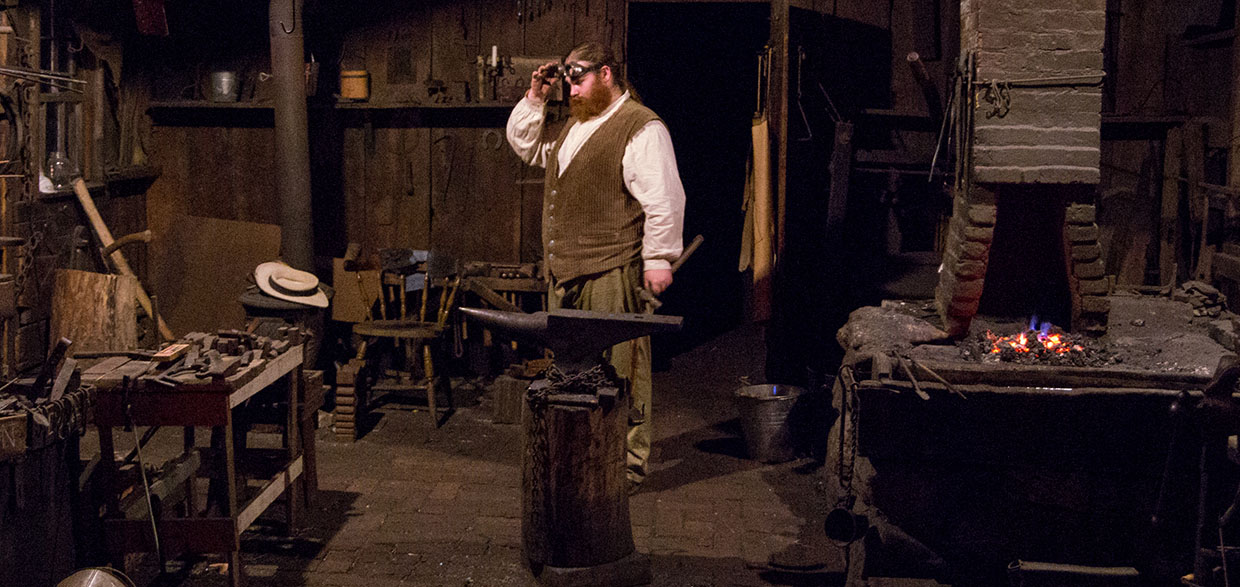 a blacksmith at work in his shop at Black Creek Pioneer Village