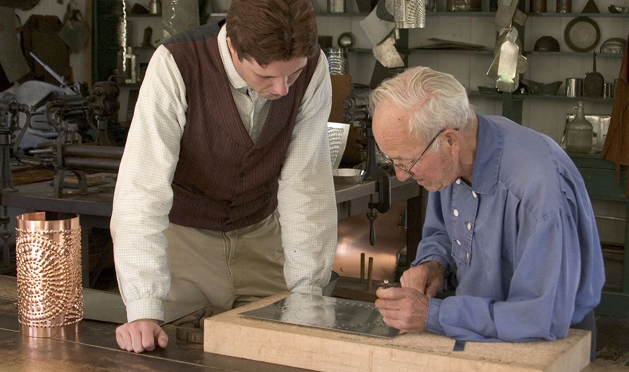 The Village tinsmith at work.