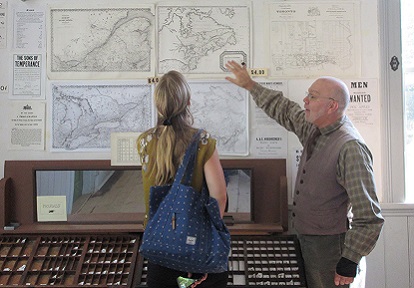 Black Creek volunteer speaks to visitor in the Printing Office