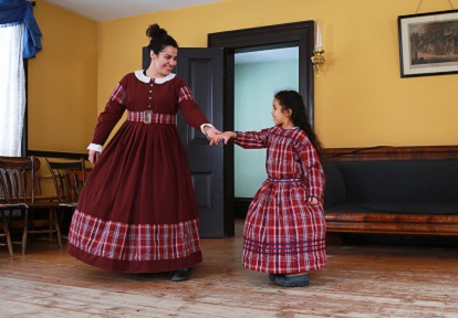 a woman and a young girl model pioneer dresses at a Black Creek Pioneer Village Discovery Station