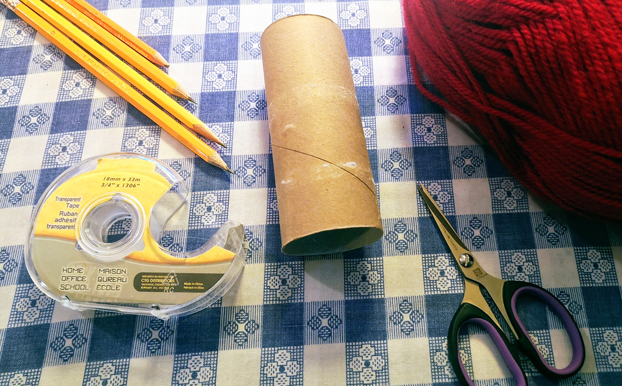 toilet paper roll with yarn and other supplies for corking tutorial