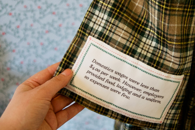 A label sewn into a garment in the Girls Bedroom portion of the Flynn House exhibit tells part of the story of women in the 19th century