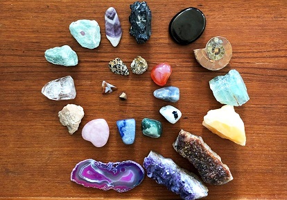 a collection of unusual rocks organized by size on a wooden tray