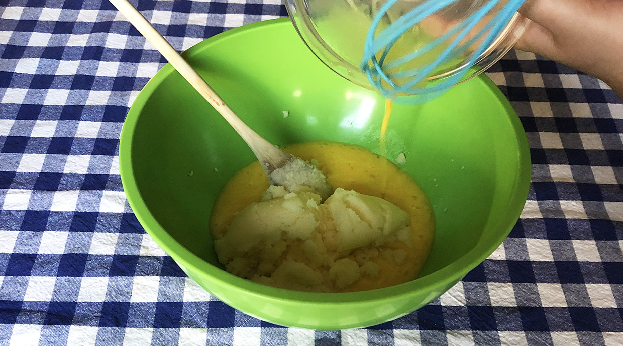 baker adds eggs to butter and sugar mixture