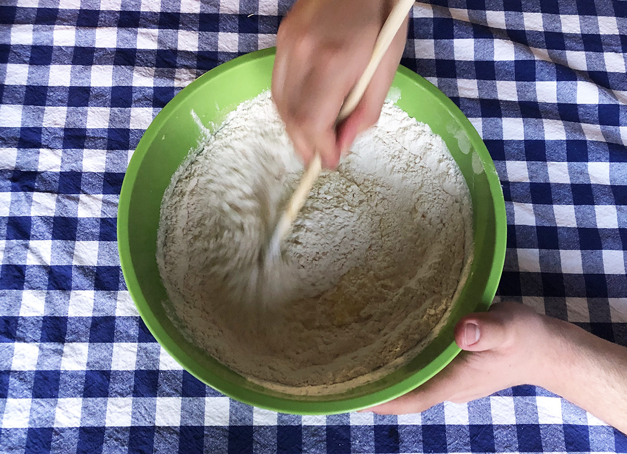 baker mixes together cup cake ingredients