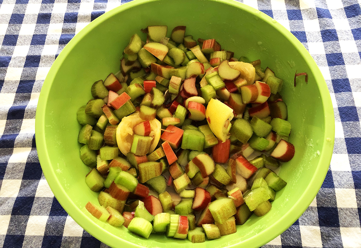 chopped rhubarb in a bowl with lemon rinds