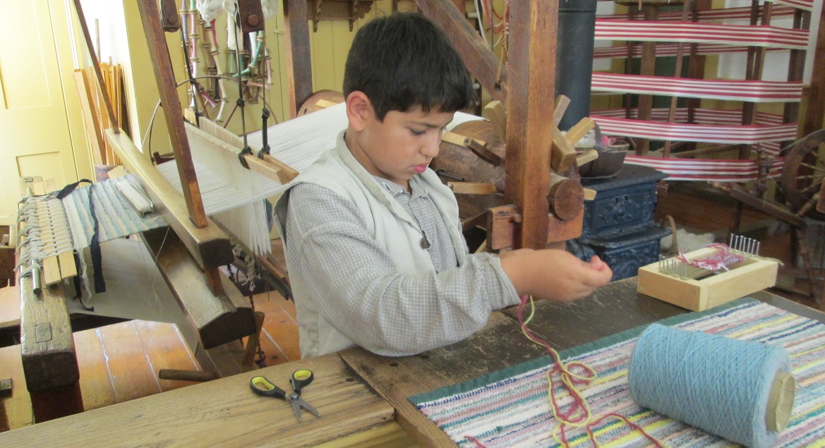 summer camper learns 19th century weaving technique at Black Creek Pioneer Village