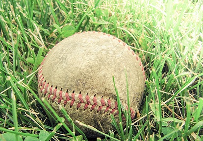 battered baseball lying in the grass