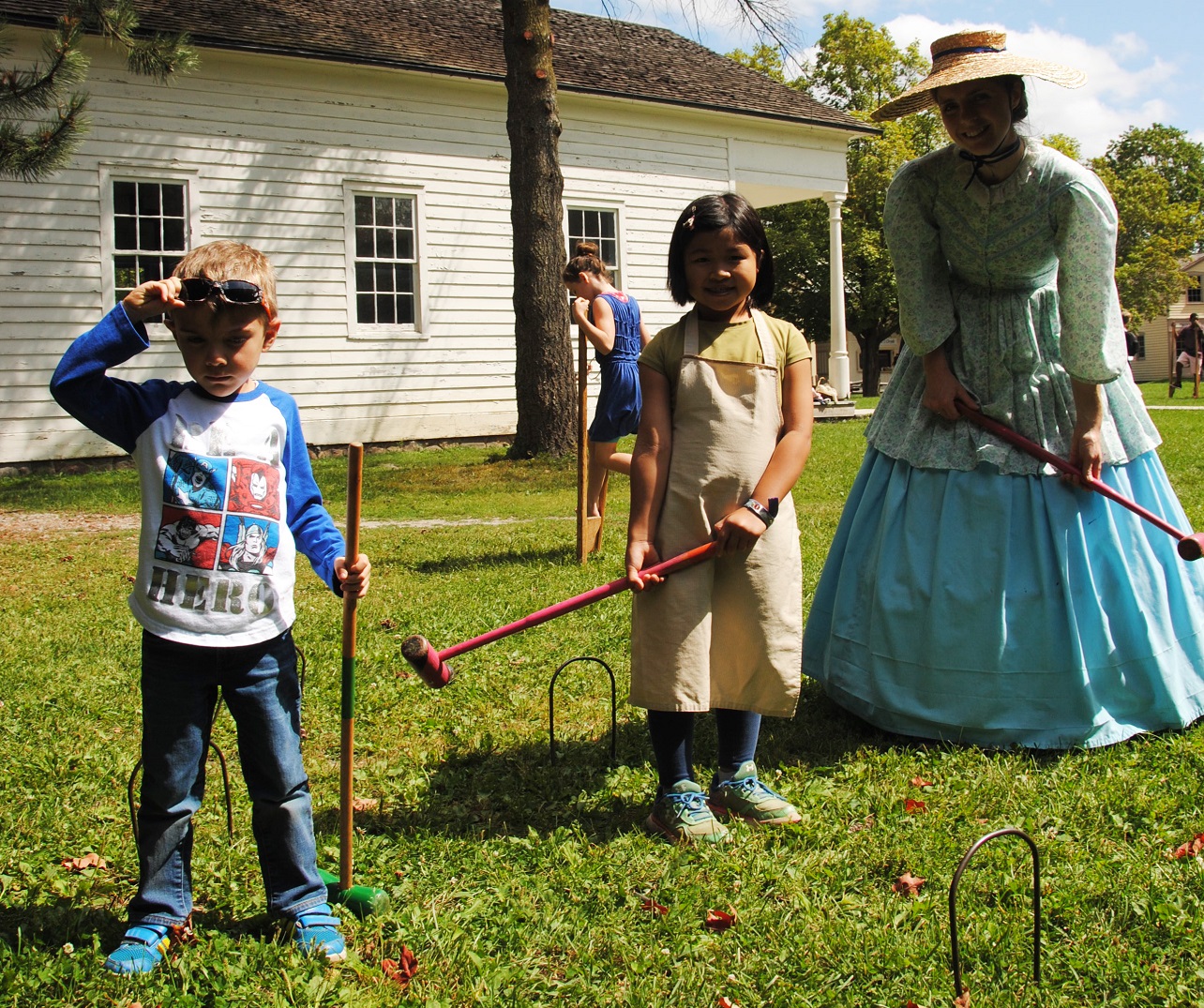 children play croquet with costumed educator on a summer day at the Village at Black Creek