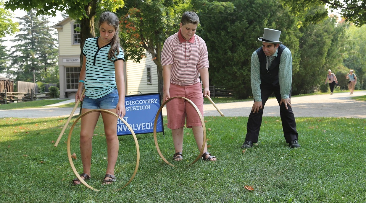 students learn to play traditional Victorian stick and hoop game