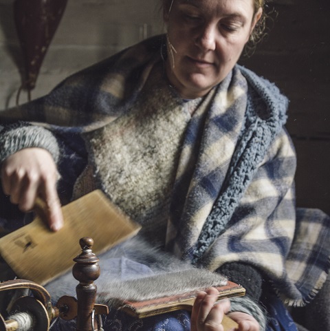 history actor at Black Creek Pioneer Village demonstrates 19th century method of carding wool