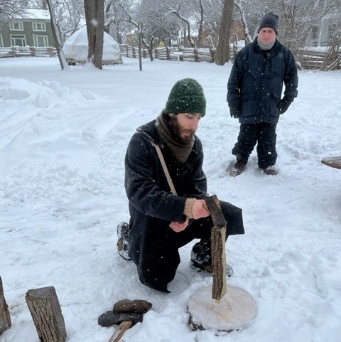 history actors split logs on a winter day at Black Creek Pioneer Village