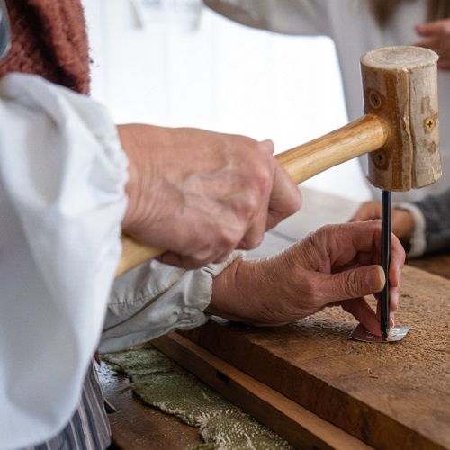 costumed educator demonstrates traditional 19th method of tin making