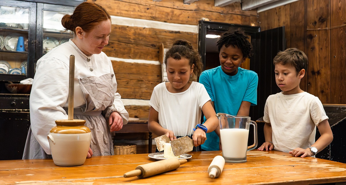 costumed educator at Black Creek Village teaches students how to prepare a traditional 19th century recipe